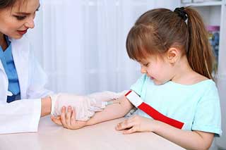 врач берет кровь из вены у ребенка